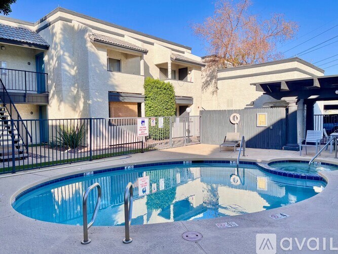 A pool in front of a building with a sign that says "AVAIL".