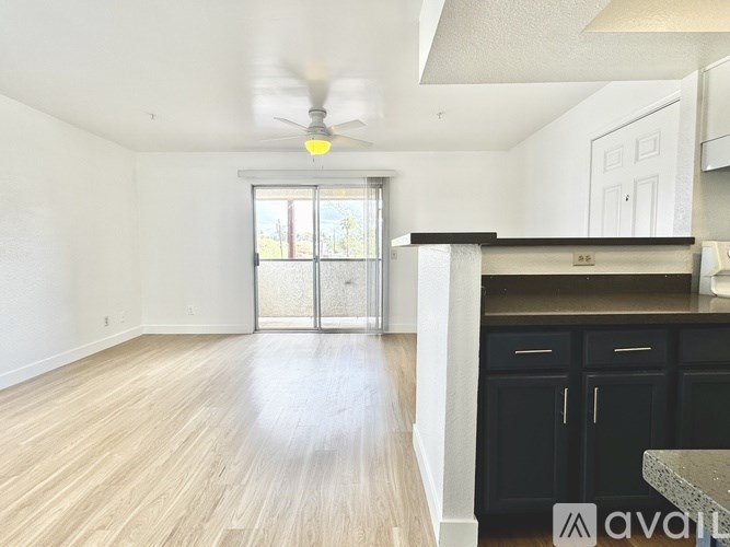 A room with a ceiling fan and a window with blinds.