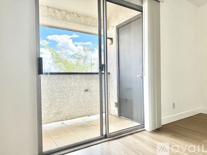 A room with a sliding glass door leading to a balcony.