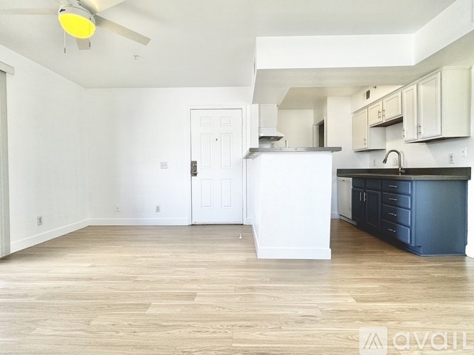 A kitchen with white cabinets and a black island.