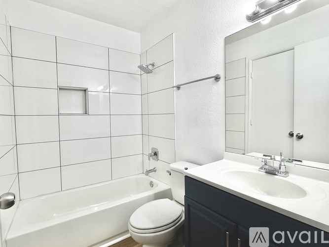 A bathroom with a white tub, toilet, and sink.