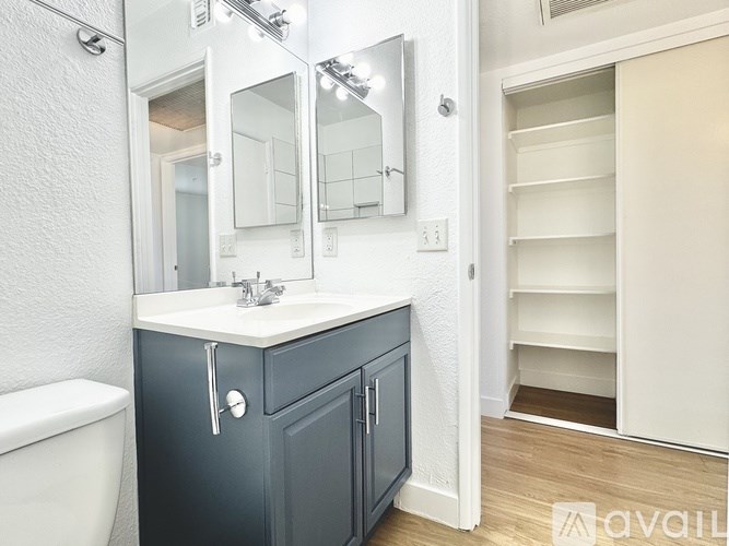 A bathroom with a white sink and a grey cabinet.