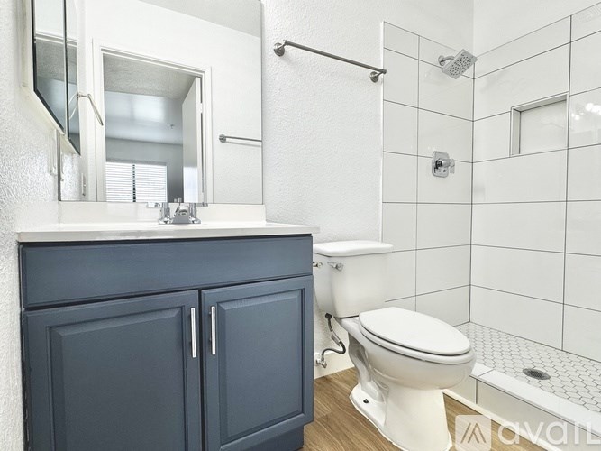 A white toilet sits next to a white sink in a bathroom.
