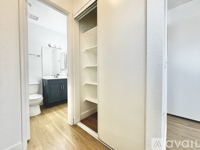 A white door is open to a bathroom with a toilet and a sink.