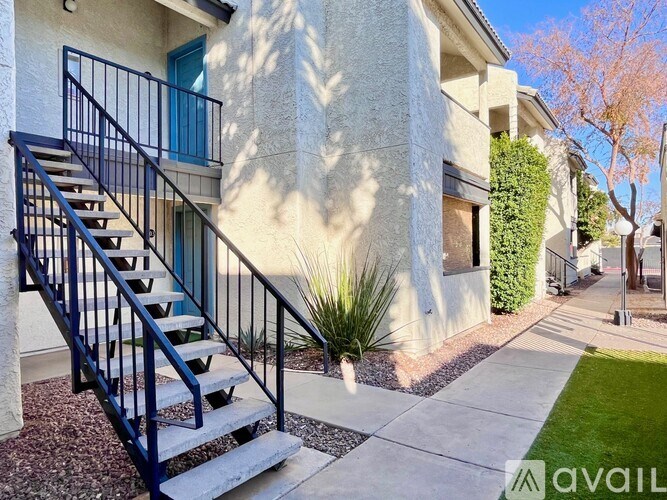 A house with a blue door and a black railing staircase.