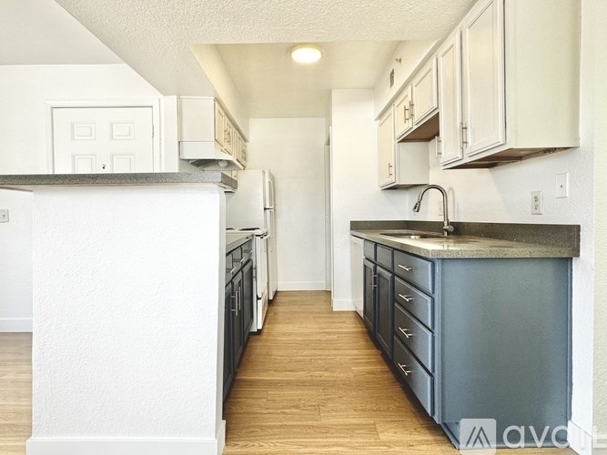 A kitchen with white cabinets and a dark counter.