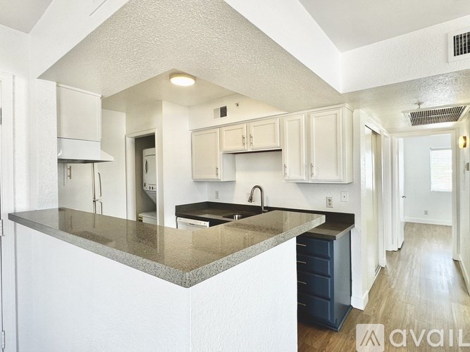 A kitchen with white cabinets and a granite countertop.