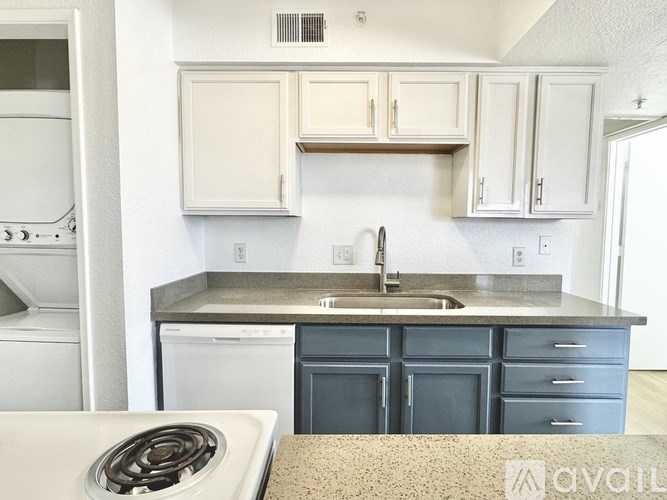 A kitchen with a white stove top oven and a granite counter top.