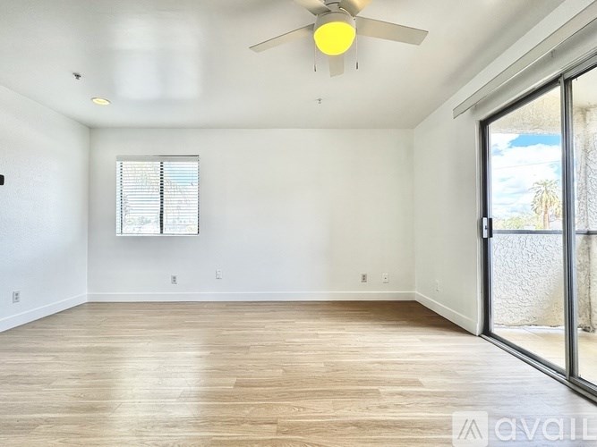 A room with a ceiling fan and sliding glass doors.