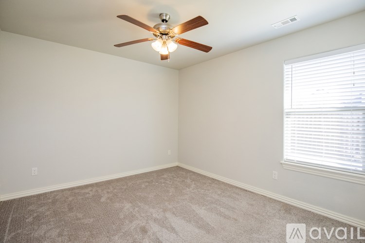 A room with a ceiling fan and carpeted floor.