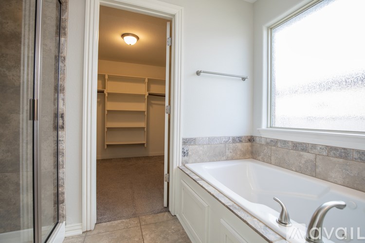 A bathroom with a tub, sink, and a walk-in shower.