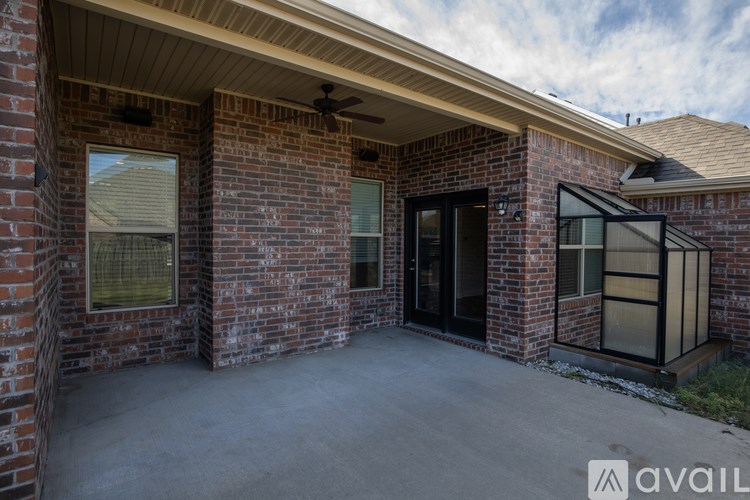 A brick house with a black door and a fan on the roof.