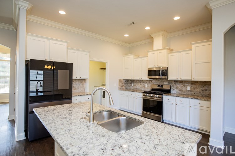 A kitchen with granite countertops and white cabinets.