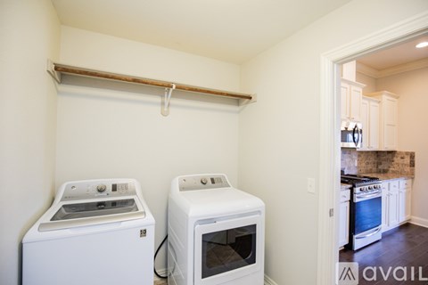 A white oven and microwave are on a shelf in a kitchen.