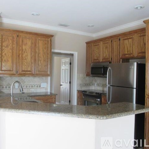 A kitchen with wooden cabinets and granite countertops.