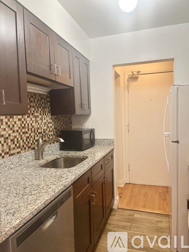 A kitchen with brown cabinets and a checkered backsplash.