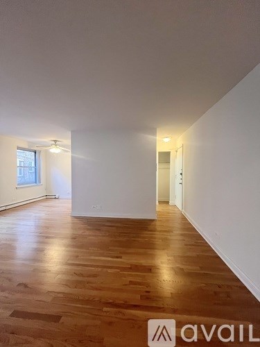 A room with wooden flooring and white walls.
