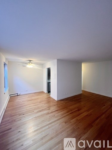 A room with wooden flooring and white walls.