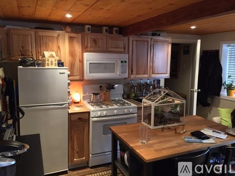 A kitchen with wooden cabinets and a white refrigerator.