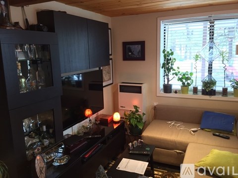 A living room with a couch, a table, a cabinet, and a window.