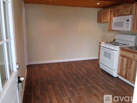A kitchen with wooden cabinets and a white stove top oven.