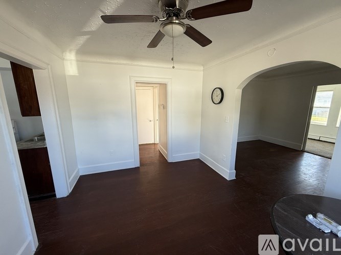 A room with a ceiling fan and a clock on the wall.