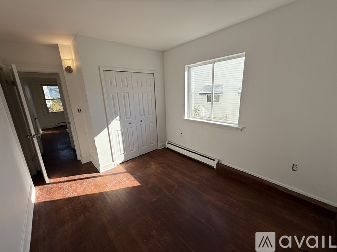 A room with a white door and a window with blinds.