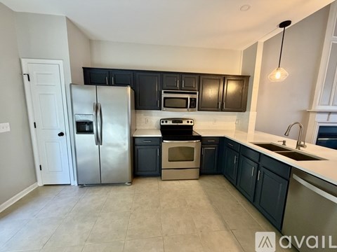 A kitchen with black cabinets and stainless steel appliances.