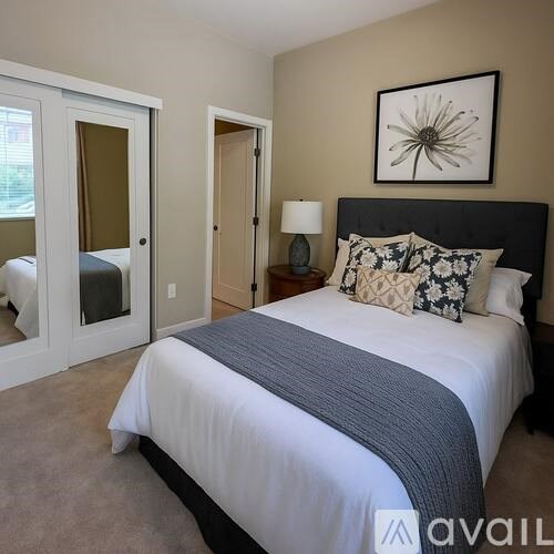 A bedroom with a large bed and a painting above it.