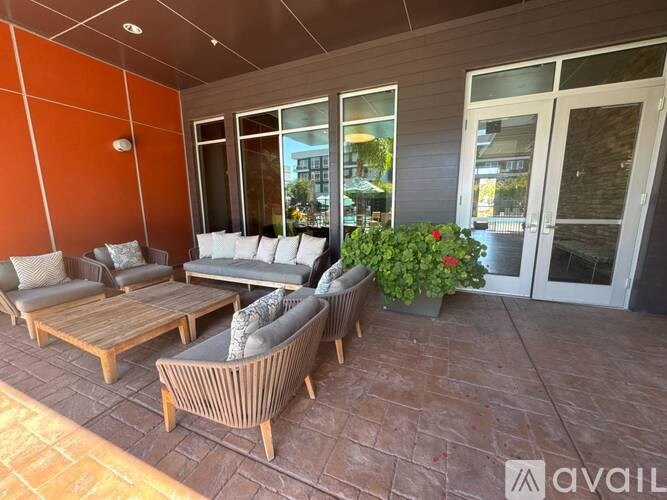 A patio with a couch, chairs, and a table with a potted plant.