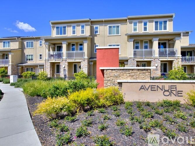 A row of apartment buildings with the name "Avenue One" on the front.