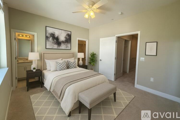 A bedroom with a large bed and a ceiling fan.