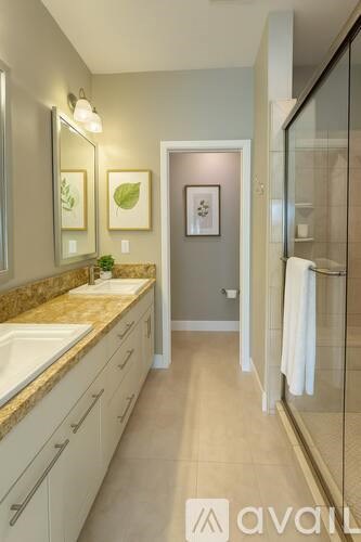 A bathroom with a sink, mirror, and a shower.