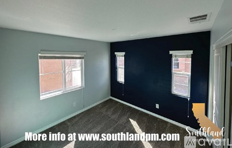 A room with a window and a wall with a paper on it.