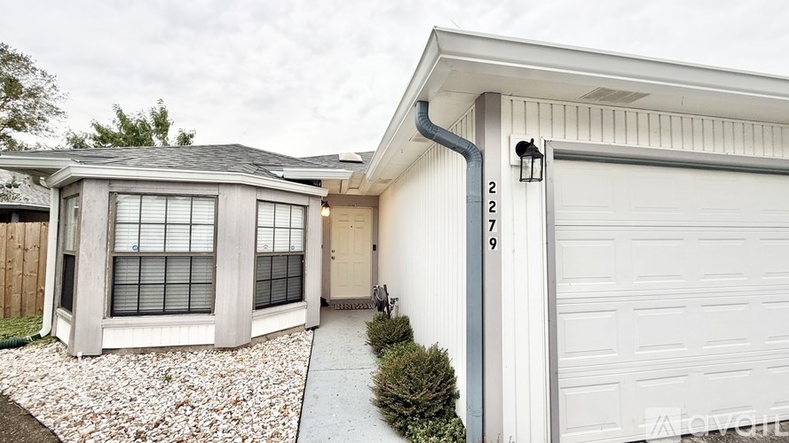 A house with a garage and a driveway leading to it.