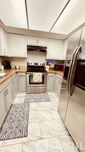 A kitchen with a stove top oven and a refrigerator.
