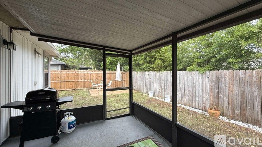 A patio with a grill and a chair is shown.