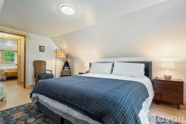 A bedroom with a large bed and a nightstand.