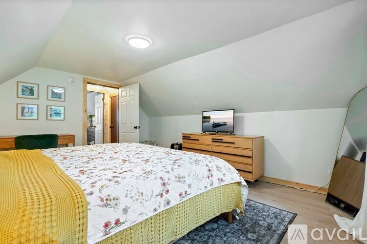 A bedroom with a bed, dresser, and television.