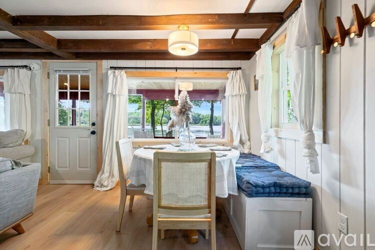 A dining area with a table set for two and a bed with a blue mattress.