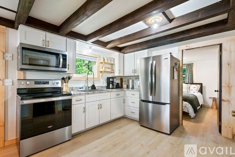 A kitchen with a refrigerator, oven, and microwave.