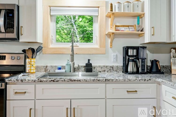 A kitchen with white cabinets and a window.