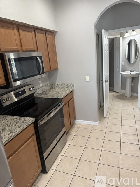 A kitchen with a black stove top oven and a microwave above it.