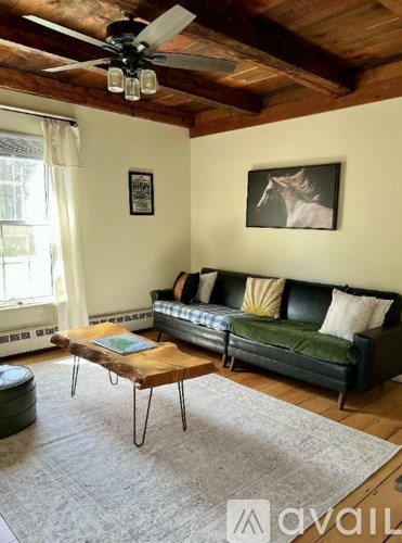 A living room with a green couch and a wooden coffee table.