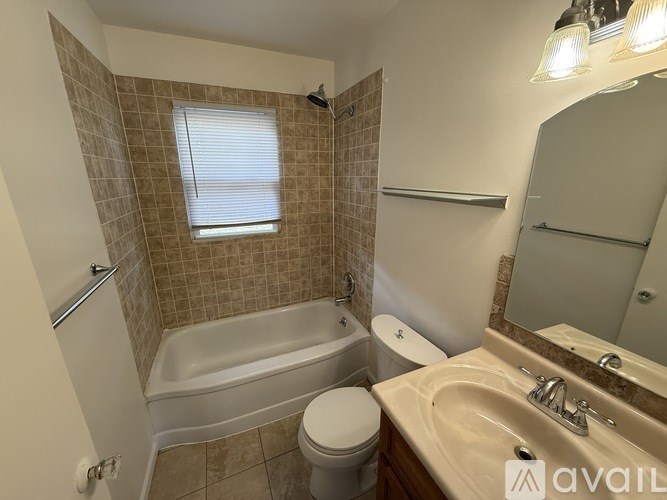 A bathroom with a toilet, sink, and bathtub.