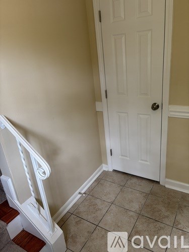 A white door is in a room with a white wall.