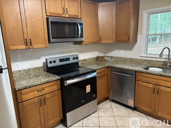 A kitchen with wooden cabinets and granite countertops.
