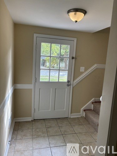 A white door with a glass window is in the middle of a hallway.
