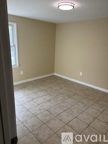 A room with beige walls and a tiled floor.