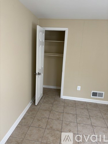 A room with a white door and a tiled floor.